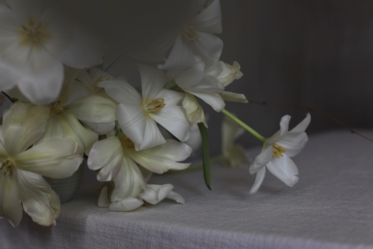 white tulips with rough linen table cloth